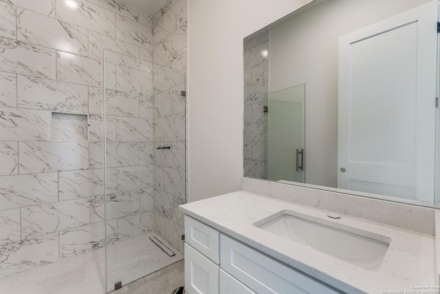 bathroom featuring walk in shower and vanity