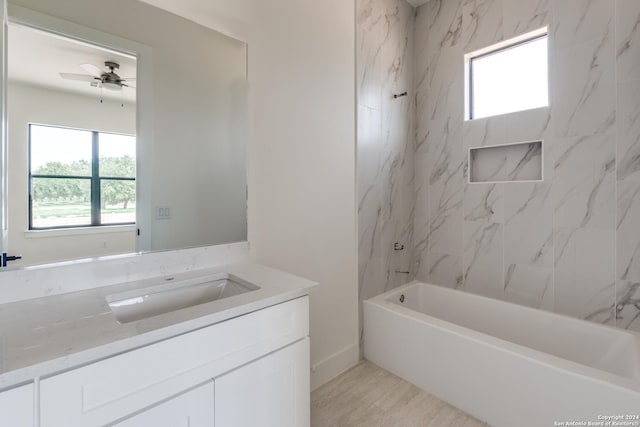 bathroom featuring tiled shower / bath combo, vanity, and ceiling fan