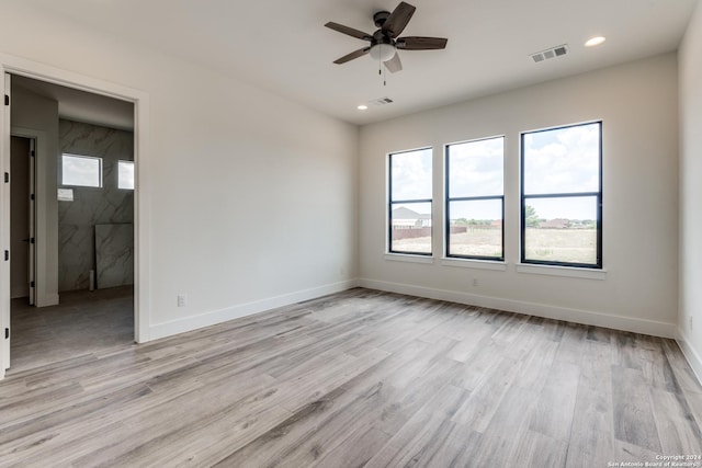 spare room with ceiling fan and light wood-type flooring