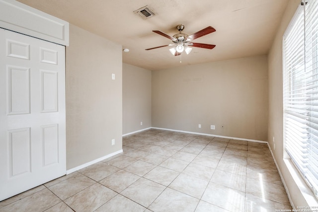 tiled empty room with ceiling fan