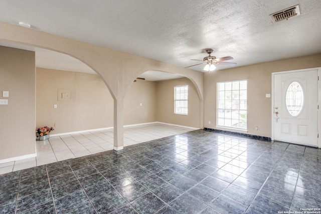 foyer featuring tile patterned floors, a textured ceiling, and ceiling fan