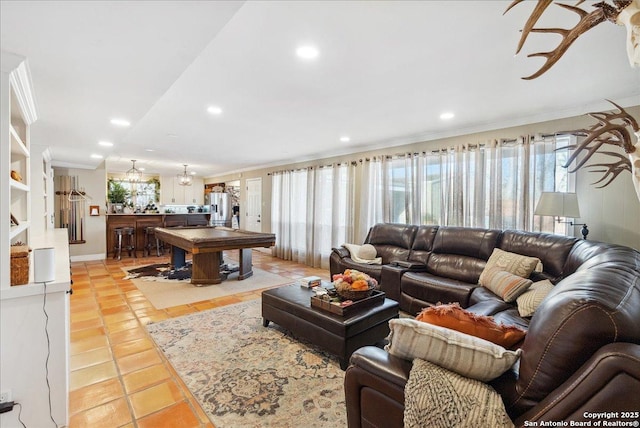 tiled living room featuring ornamental molding and a healthy amount of sunlight