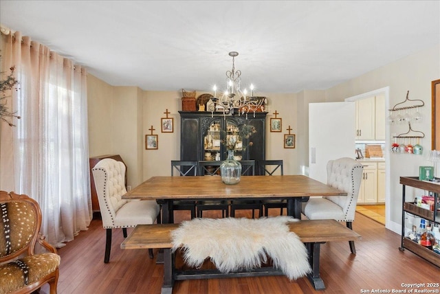 dining space featuring dark wood-type flooring and a chandelier