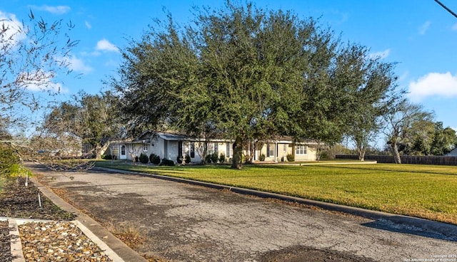 obstructed view of property featuring a front lawn