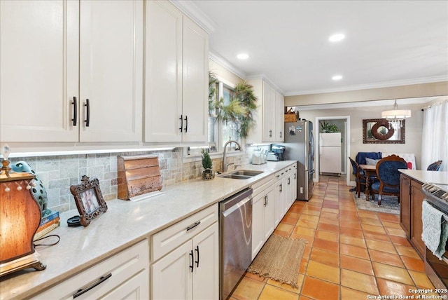 kitchen with sink, appliances with stainless steel finishes, pendant lighting, decorative backsplash, and white cabinets