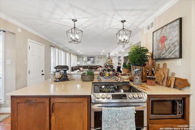 kitchen featuring an inviting chandelier, hanging light fixtures, light stone counters, and stainless steel appliances