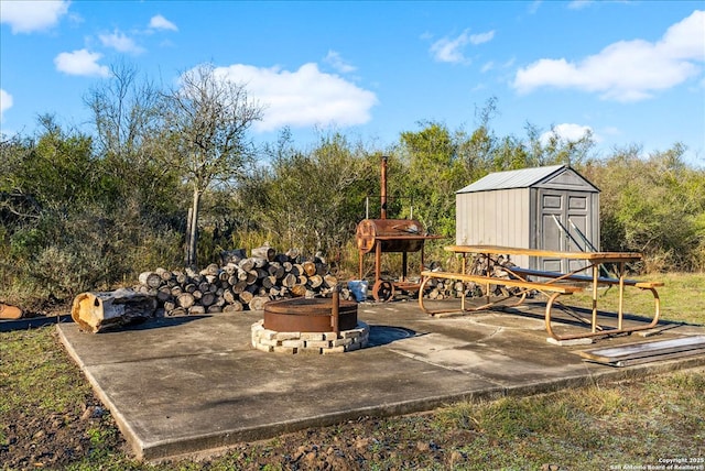 view of patio with a storage unit and an outdoor fire pit