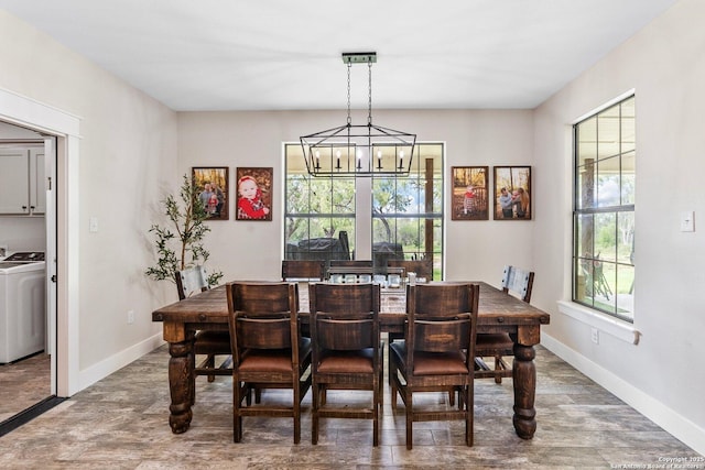 dining area with washer / clothes dryer, hardwood / wood-style flooring, and a chandelier