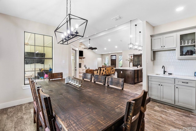 dining area featuring a barn door, ceiling fan, dark hardwood / wood-style floors, and sink