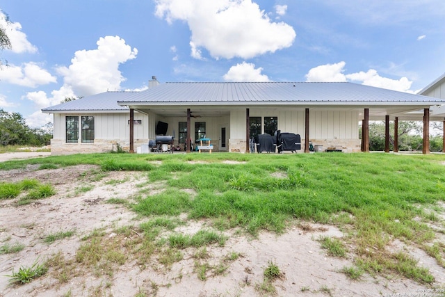 rear view of house with a yard and ceiling fan