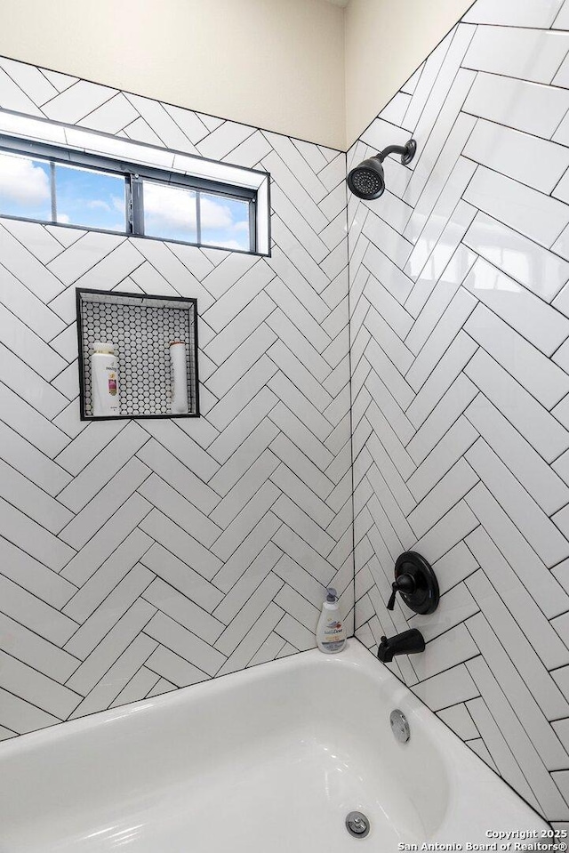 bathroom featuring tiled shower / bath