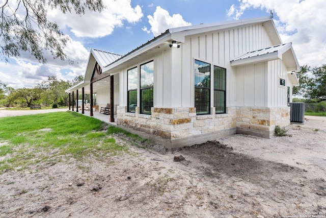 view of side of home featuring a yard, central AC unit, and a patio area