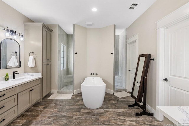 bathroom with vanity, hardwood / wood-style flooring, and plus walk in shower