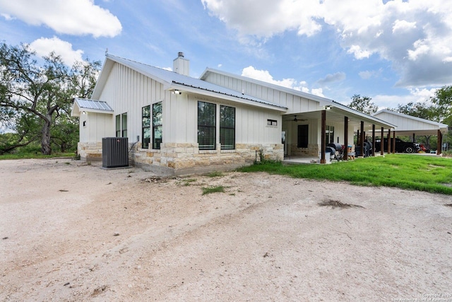 back of property with a yard and central air condition unit