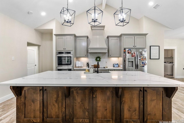 kitchen featuring hanging light fixtures, stainless steel refrigerator with ice dispenser, a large island, and lofted ceiling with beams