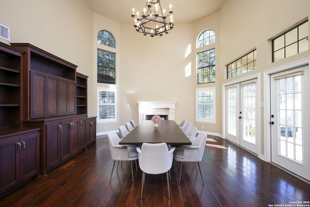 dining area featuring a notable chandelier, dark hardwood / wood-style floors, and a high ceiling