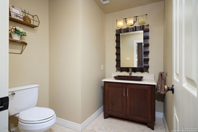 bathroom featuring tile patterned flooring, vanity, and toilet