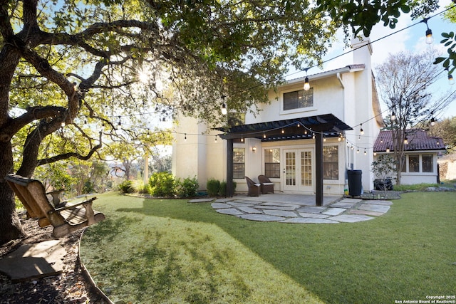 rear view of property with a patio, a lawn, and french doors