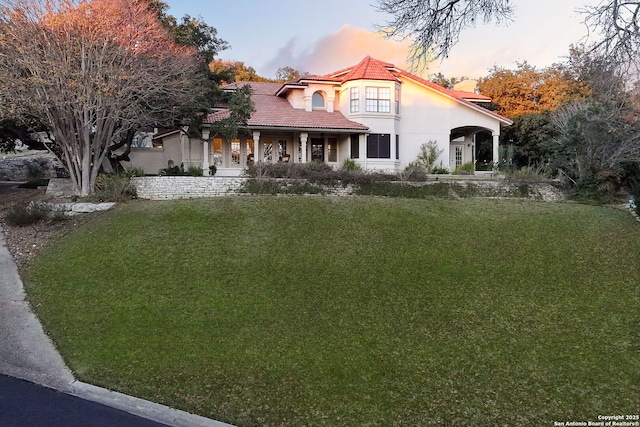 mediterranean / spanish house featuring a lawn