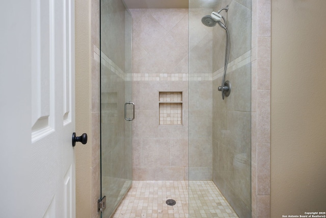 bathroom with a shower with door