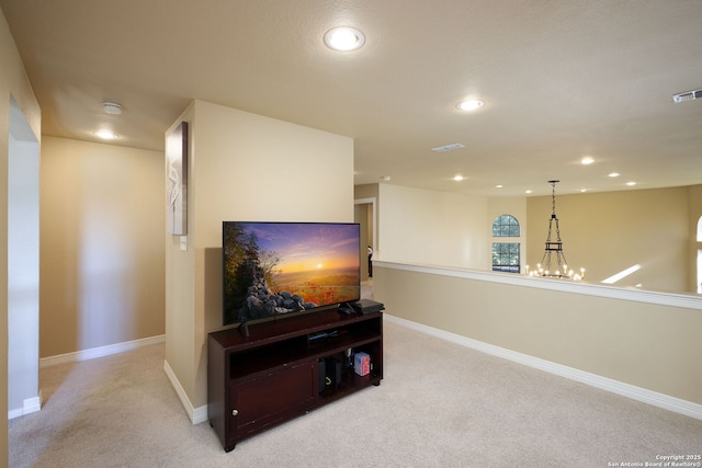 carpeted living room featuring a chandelier