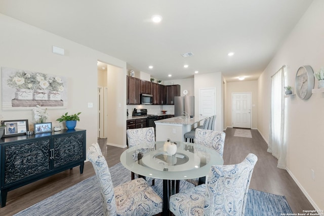 dining space with hardwood / wood-style flooring and sink