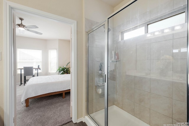 bathroom featuring ceiling fan, a healthy amount of sunlight, and a shower with shower door