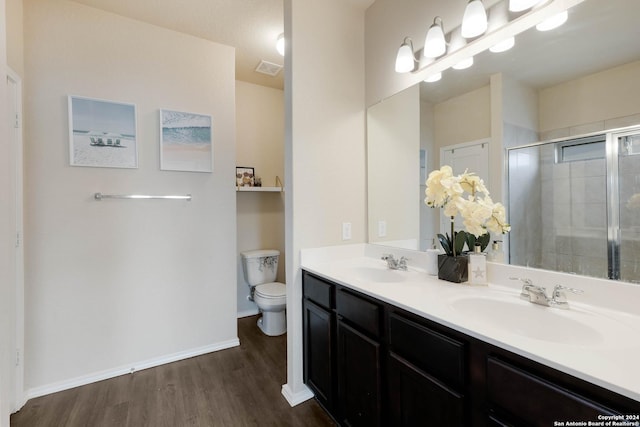 bathroom with a shower with door, wood-type flooring, vanity, and toilet