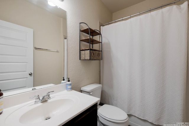 bathroom with vanity, toilet, and curtained shower