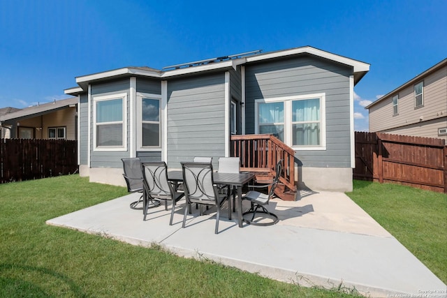 rear view of house featuring a patio and a lawn