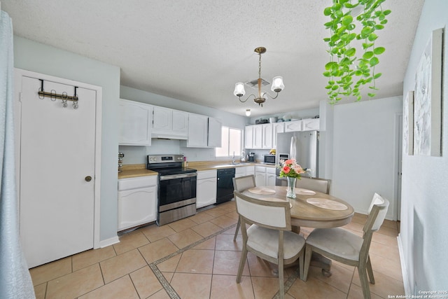 kitchen featuring light tile patterned floors, appliances with stainless steel finishes, a textured ceiling, white cabinets, and decorative light fixtures