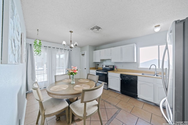 kitchen featuring pendant lighting, sink, appliances with stainless steel finishes, white cabinetry, and a textured ceiling