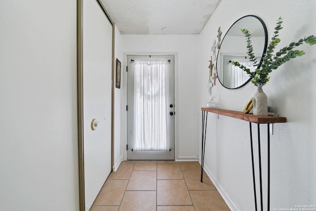 doorway with light tile patterned flooring, a textured ceiling, and a wealth of natural light