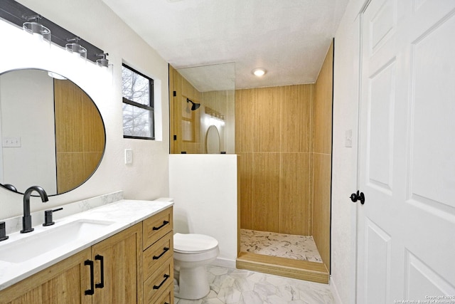 bathroom featuring a tile shower, vanity, a textured ceiling, and toilet