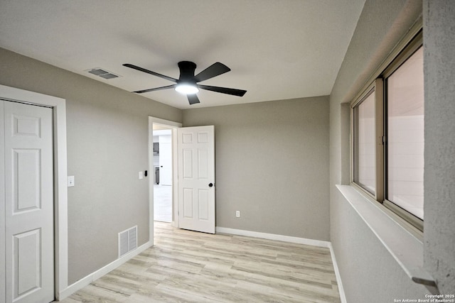 empty room with ceiling fan and light hardwood / wood-style floors