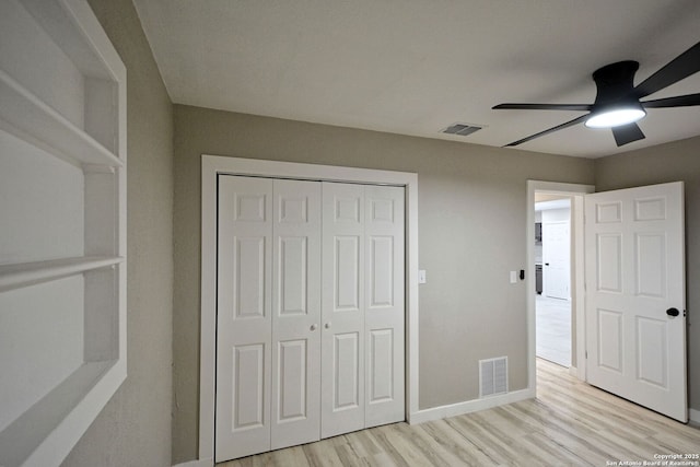 unfurnished bedroom featuring a closet, ceiling fan, and light hardwood / wood-style flooring