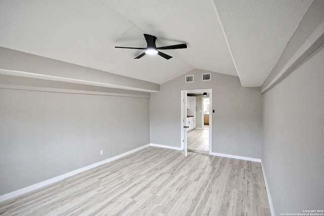 empty room featuring vaulted ceiling, ceiling fan, and light wood-type flooring