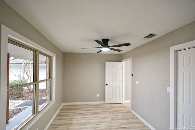 empty room with ceiling fan and light wood-type flooring