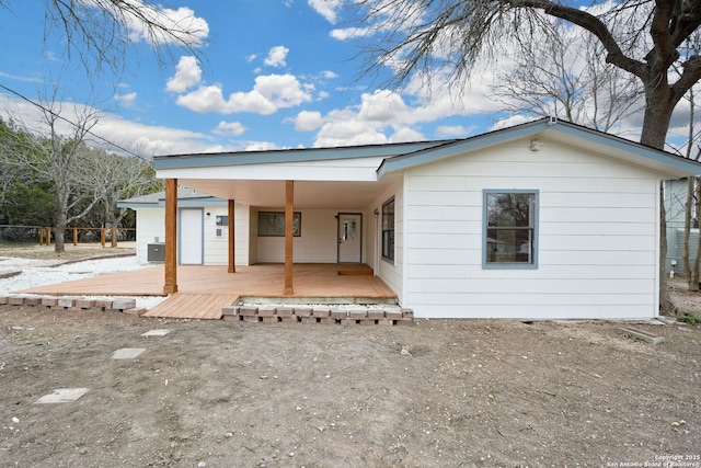 back of house featuring central AC unit and a deck