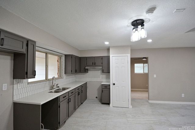 kitchen with sink, backsplash, and a textured ceiling