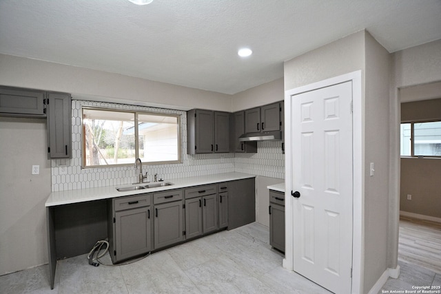 kitchen featuring tasteful backsplash, sink, and gray cabinets