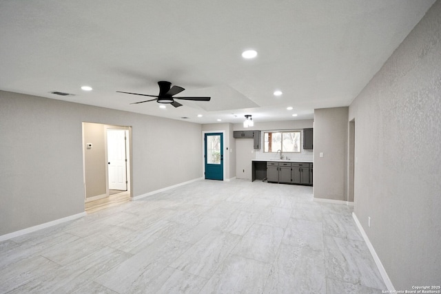 unfurnished living room with sink and ceiling fan