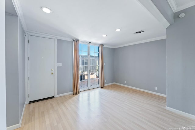 unfurnished room featuring ornamental molding and light wood-type flooring