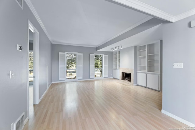 unfurnished living room featuring ornamental molding, light hardwood / wood-style flooring, a high end fireplace, and built in shelves