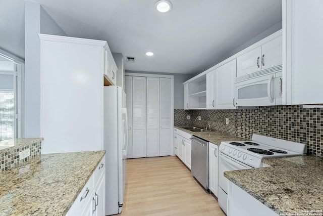 kitchen featuring sink, white cabinetry, white appliances, light stone countertops, and decorative backsplash