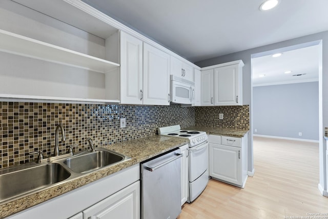 kitchen with white cabinetry, backsplash, white appliances, and sink