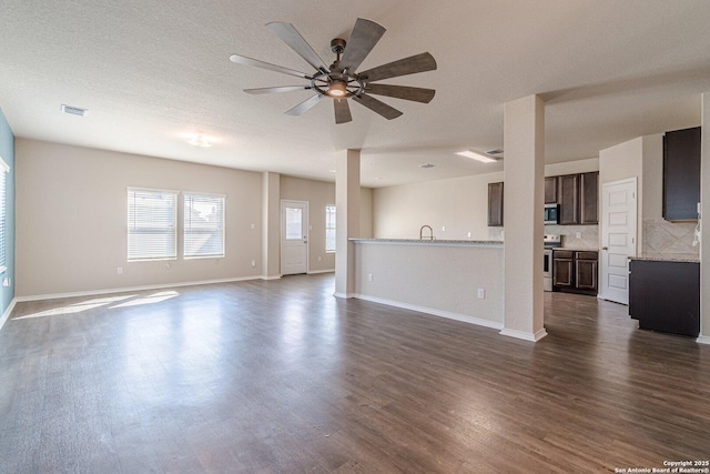 unfurnished living room with dark hardwood / wood-style flooring, sink, a textured ceiling, and ceiling fan