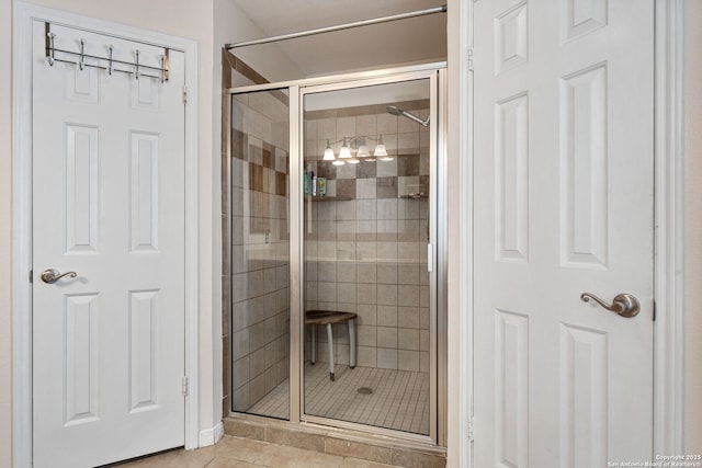 bathroom with an enclosed shower and tile patterned floors