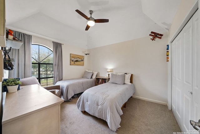 carpeted bedroom with vaulted ceiling, a closet, and ceiling fan