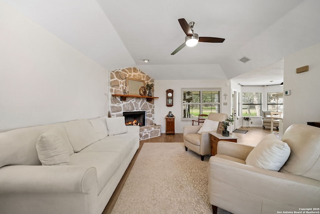 living room with wood-type flooring, lofted ceiling, ceiling fan, and a fireplace